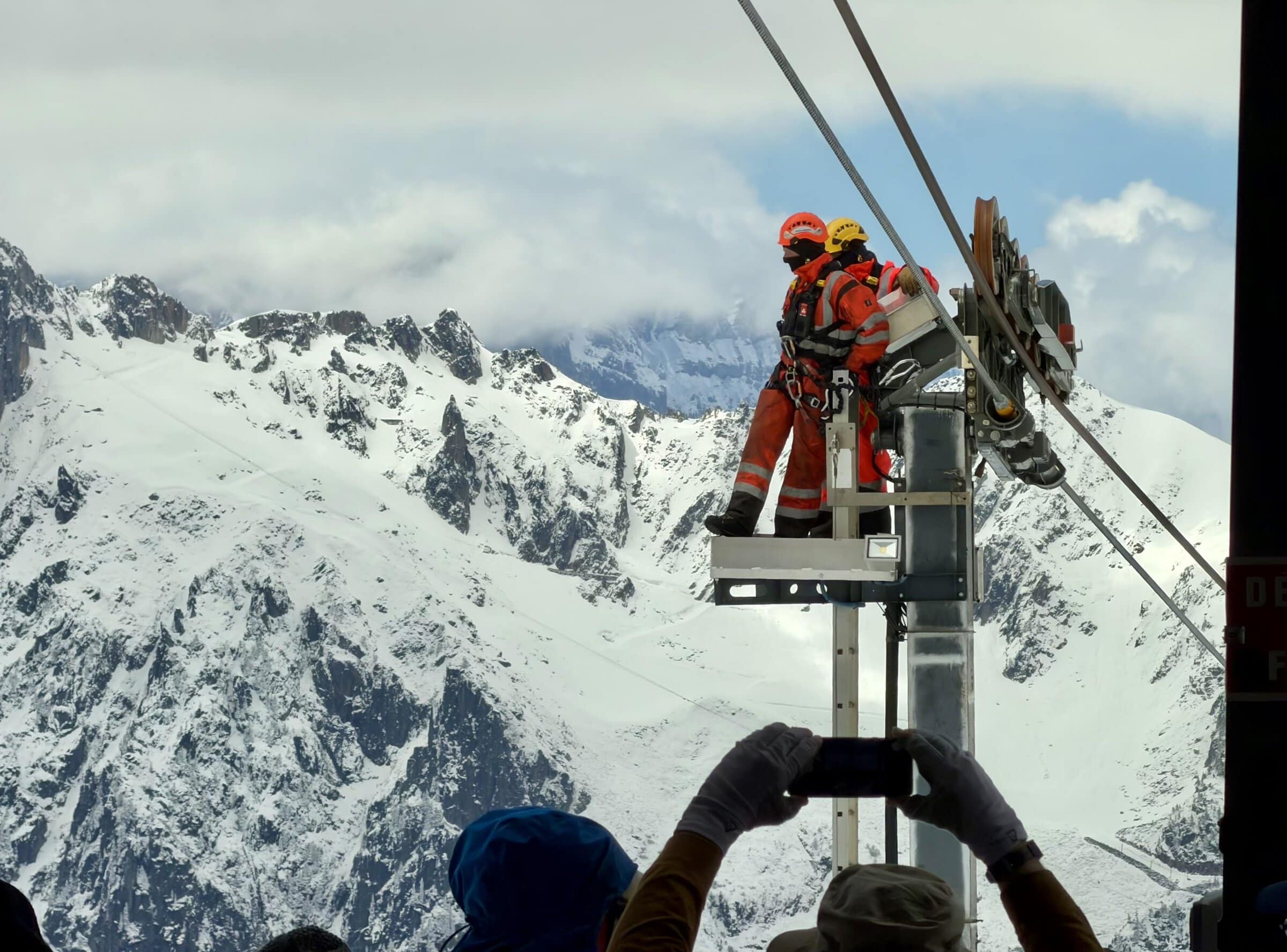 Workers on a platform above the cable car gondola