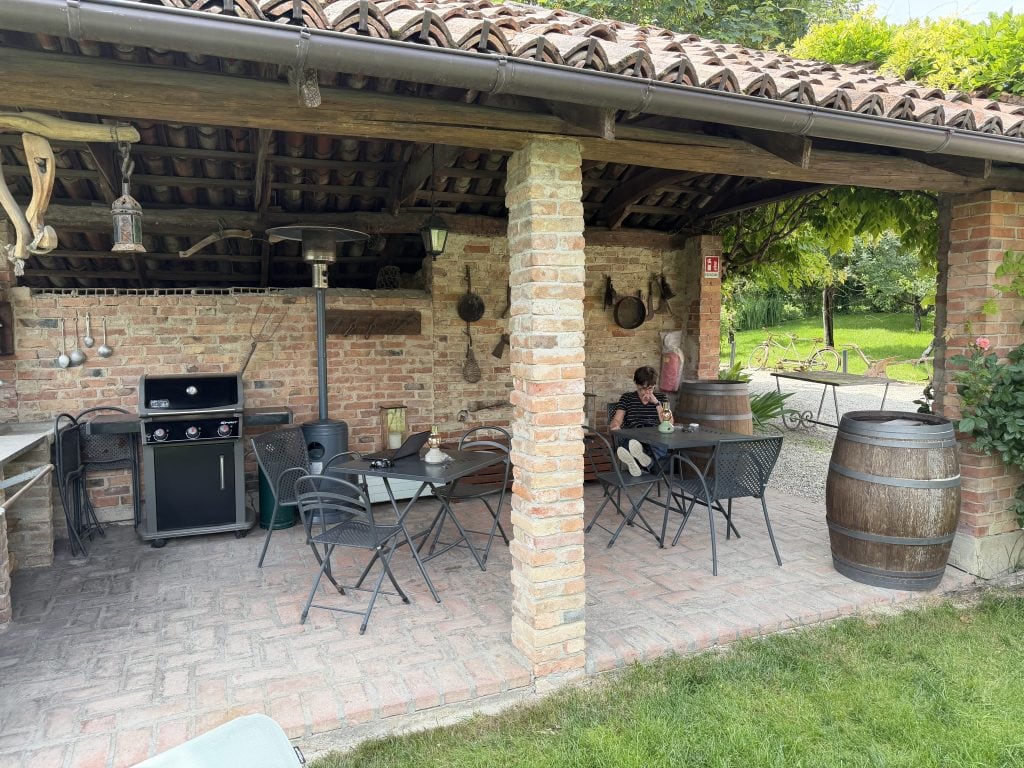 Karen relaxing under the cute tile roofed out building in the garden.