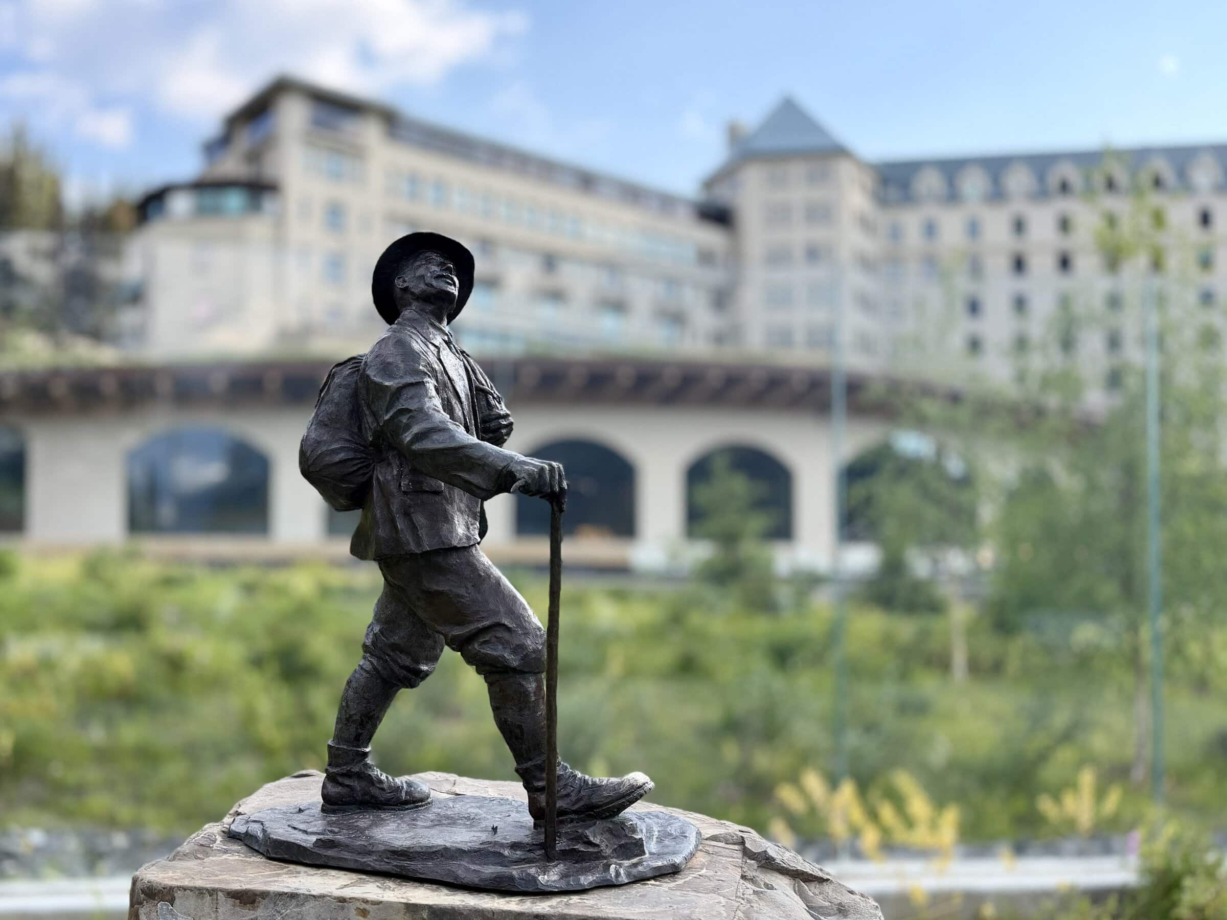 A sculpture of a hiker in front of Chateau Lake Louise